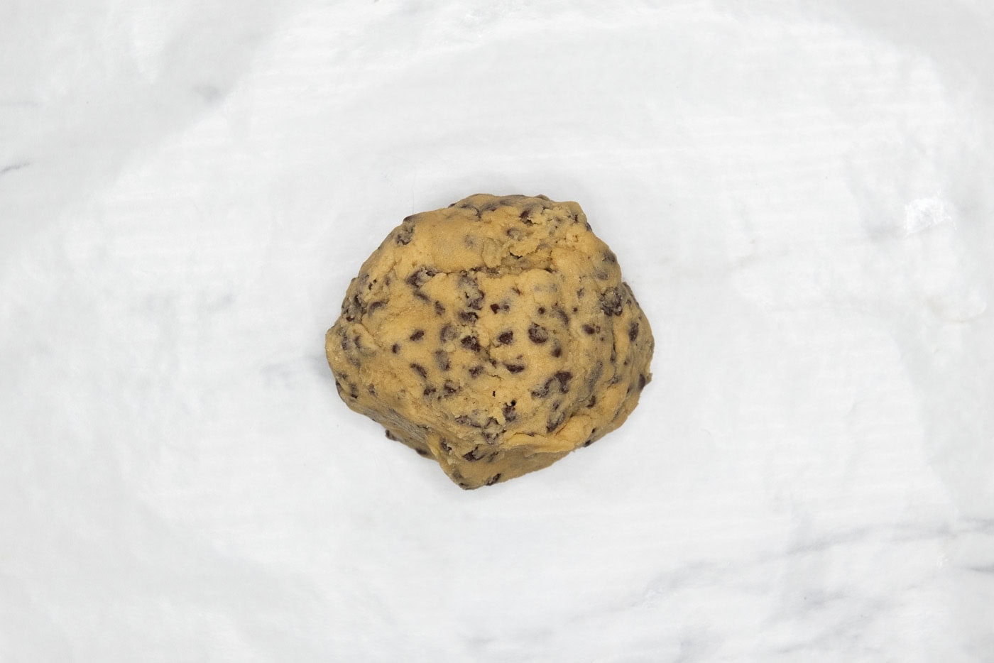 chocolate chip cookie dough ball in parchment paper