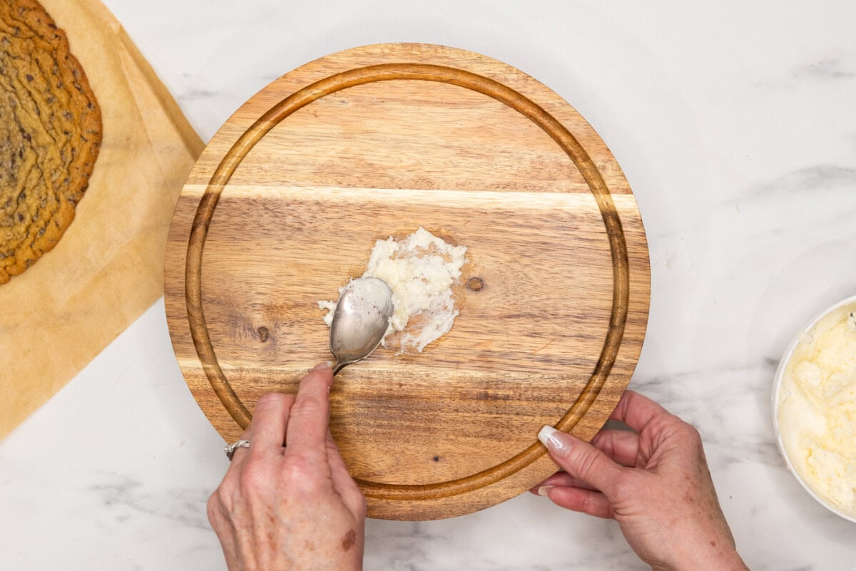 placing buttercream on bottom of cake stand