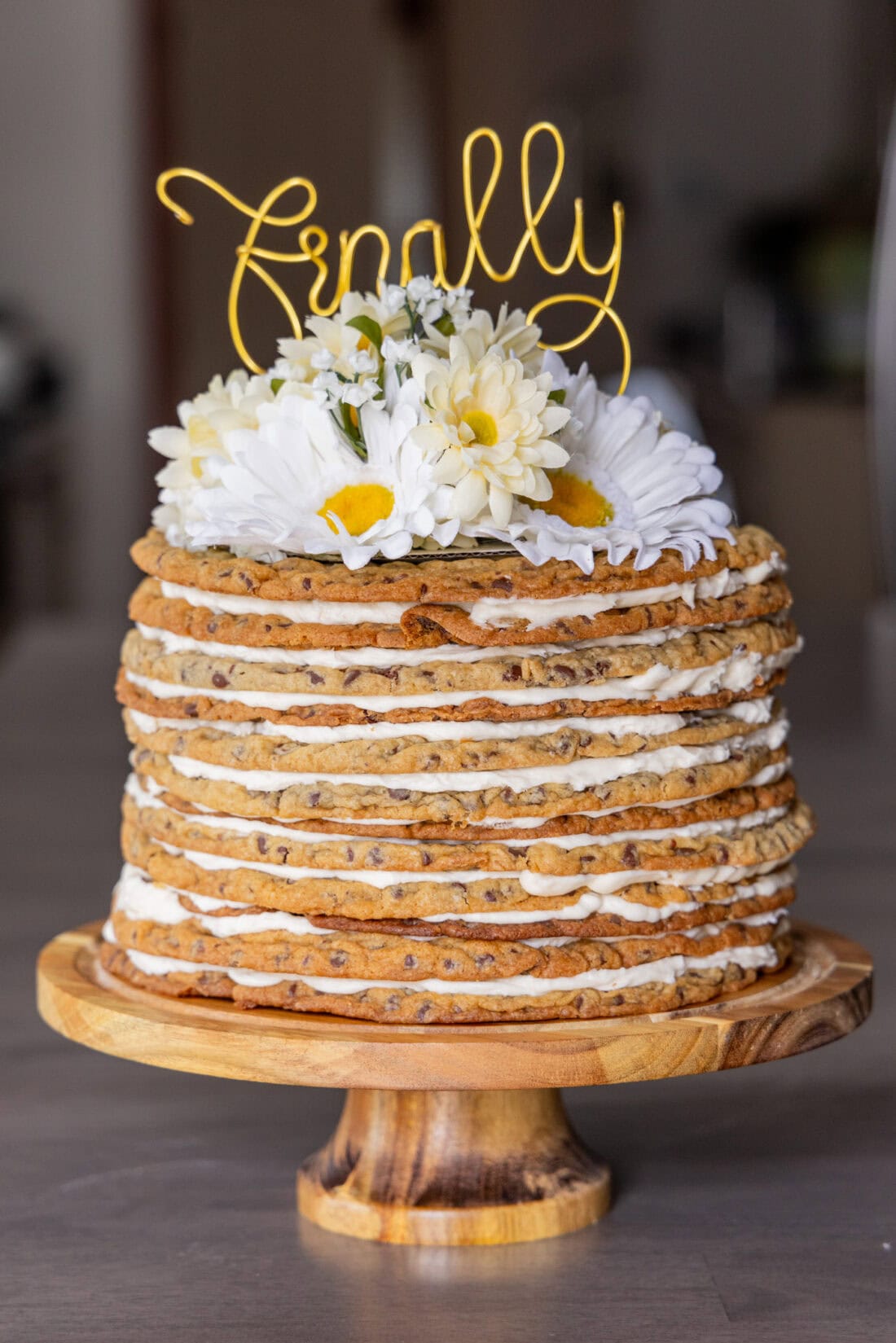 Photo of a Chocolate Chip Cookie Tower topped with flowers and a cake topper that says finally