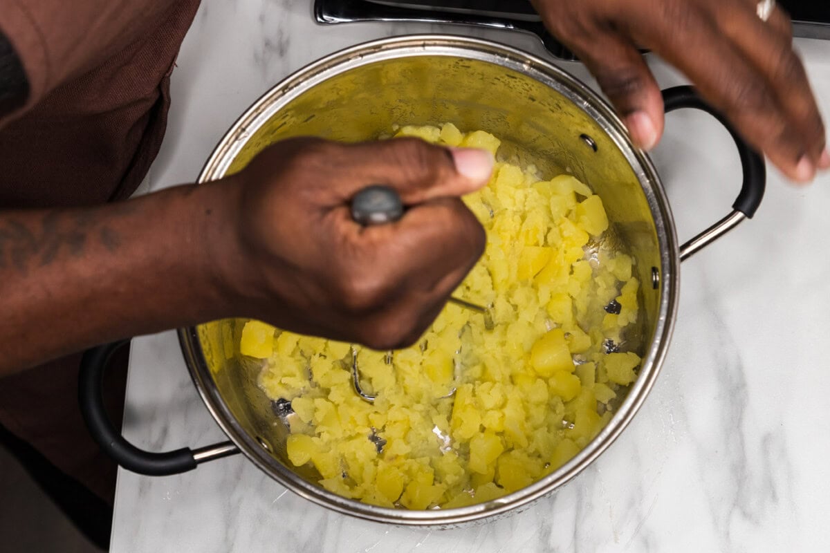 mashing potatoes in a bowl