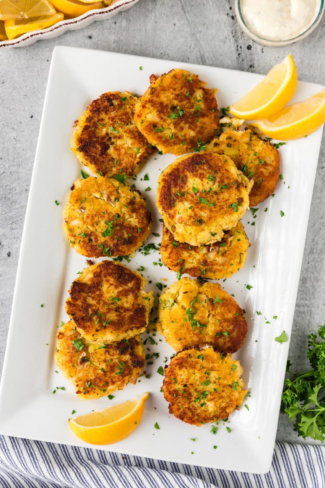 Cod Fish Cakes on a platter with lemon wedges on the side