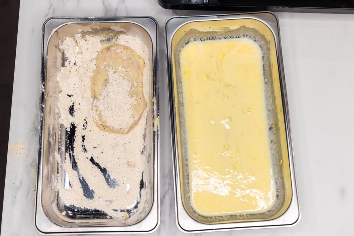 coating dredged chicken patty in flour
