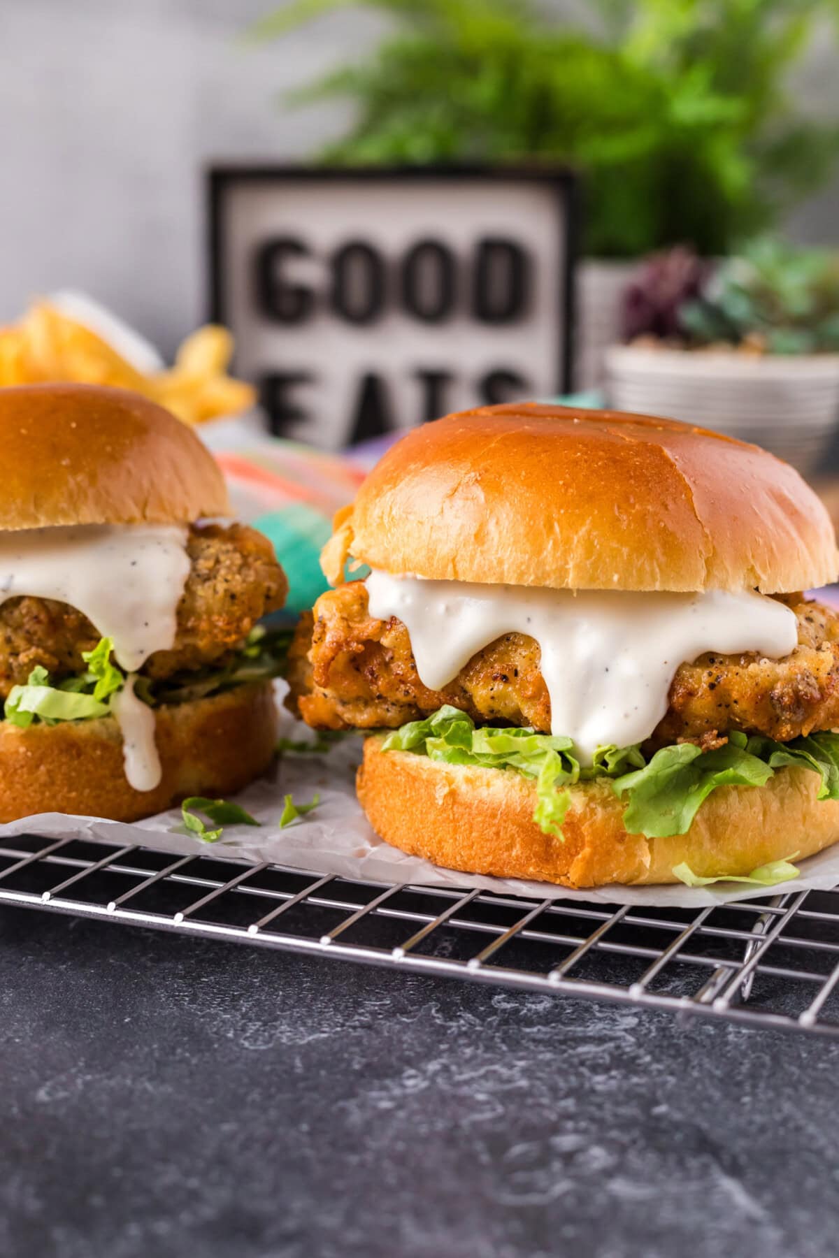 Two Crispy Chicken Burgers parchment lined wire rack