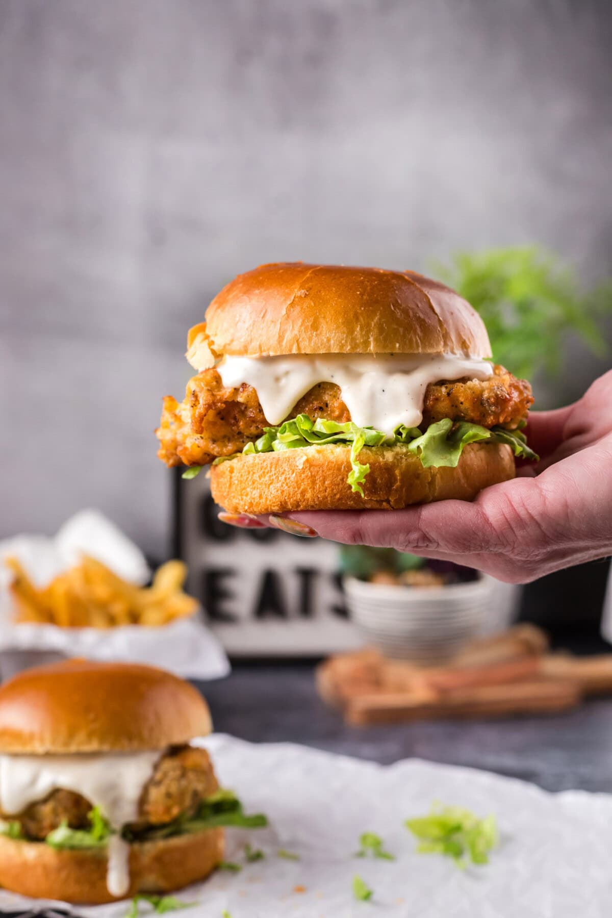 Hand holding up a Crispy Chicken Burger