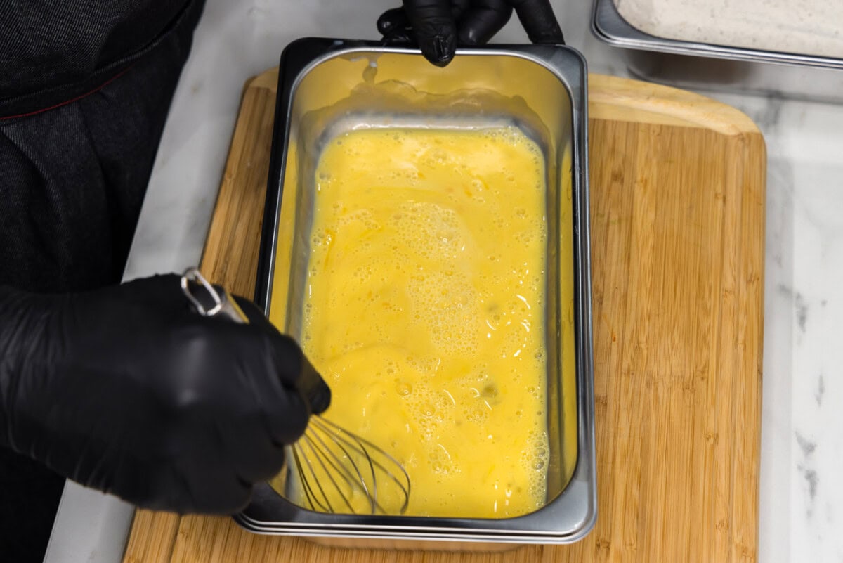 whisking eggs and buttermilk in a breading tray