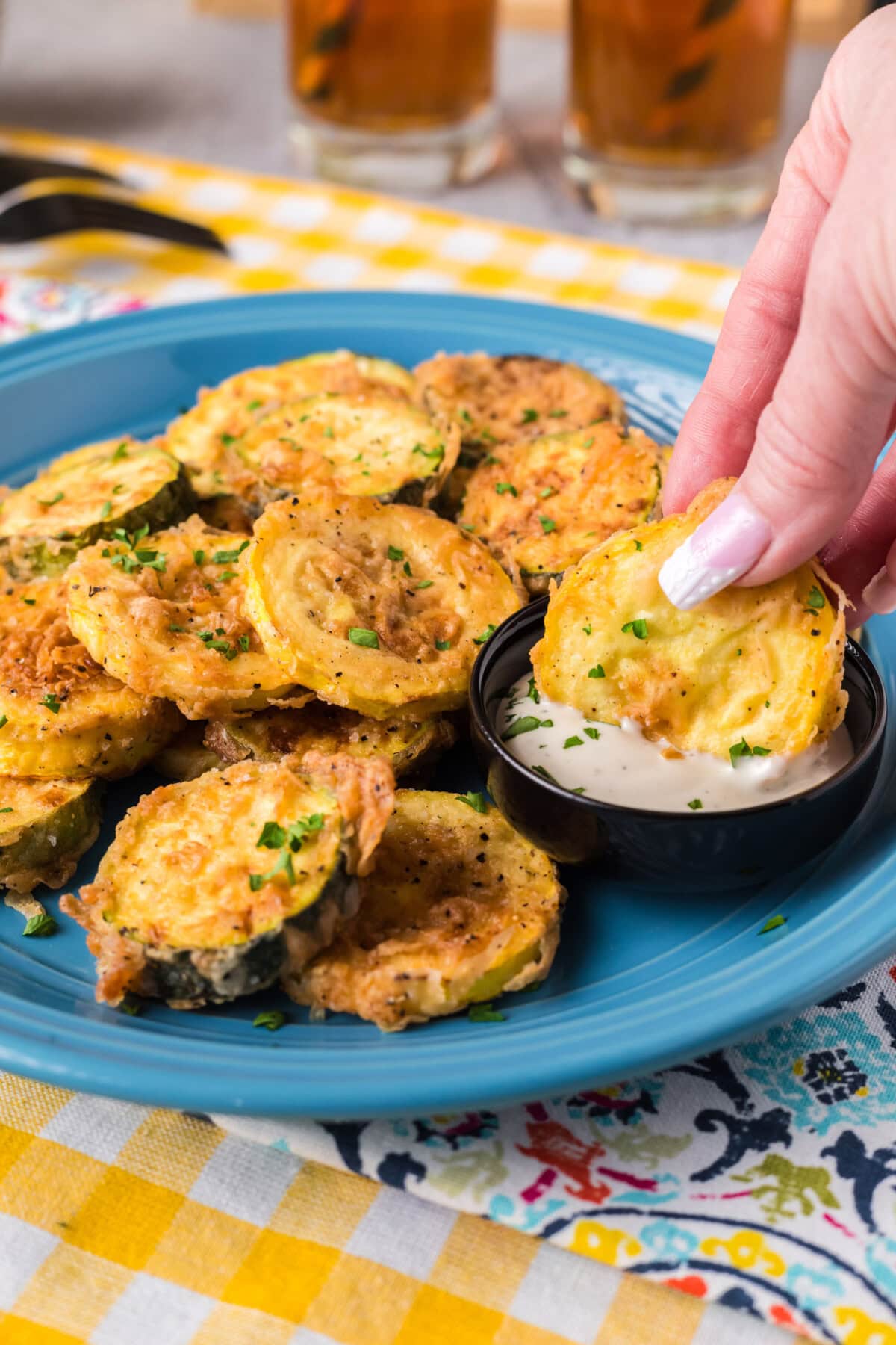 Fried Squash being dipped in ranch 