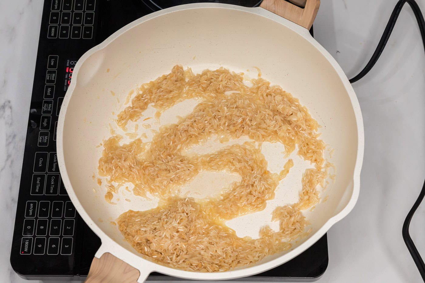 cooking minced garlic with rice in pan with butter