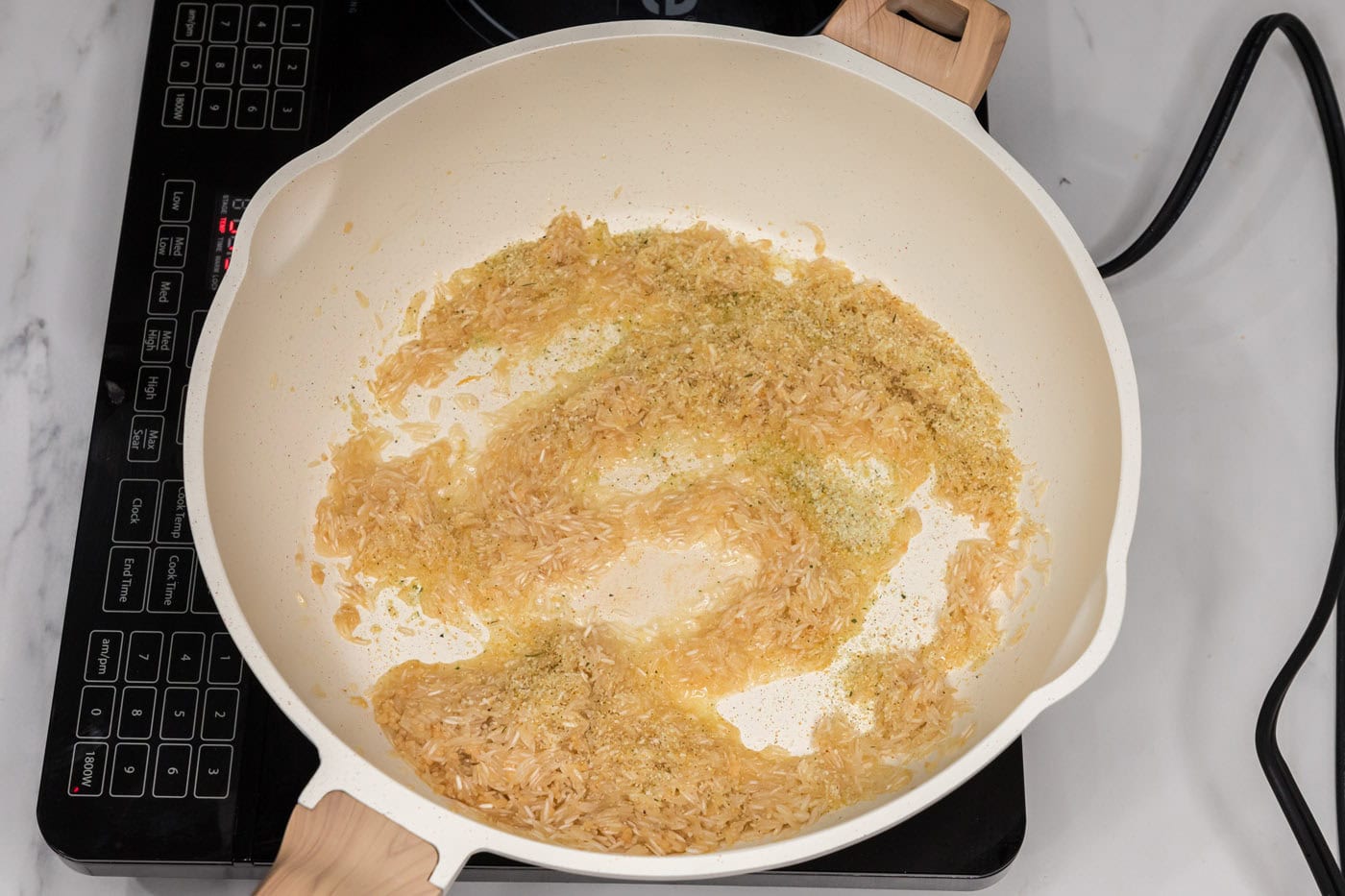 adding garlic salt to garlic butter rice in a skillet