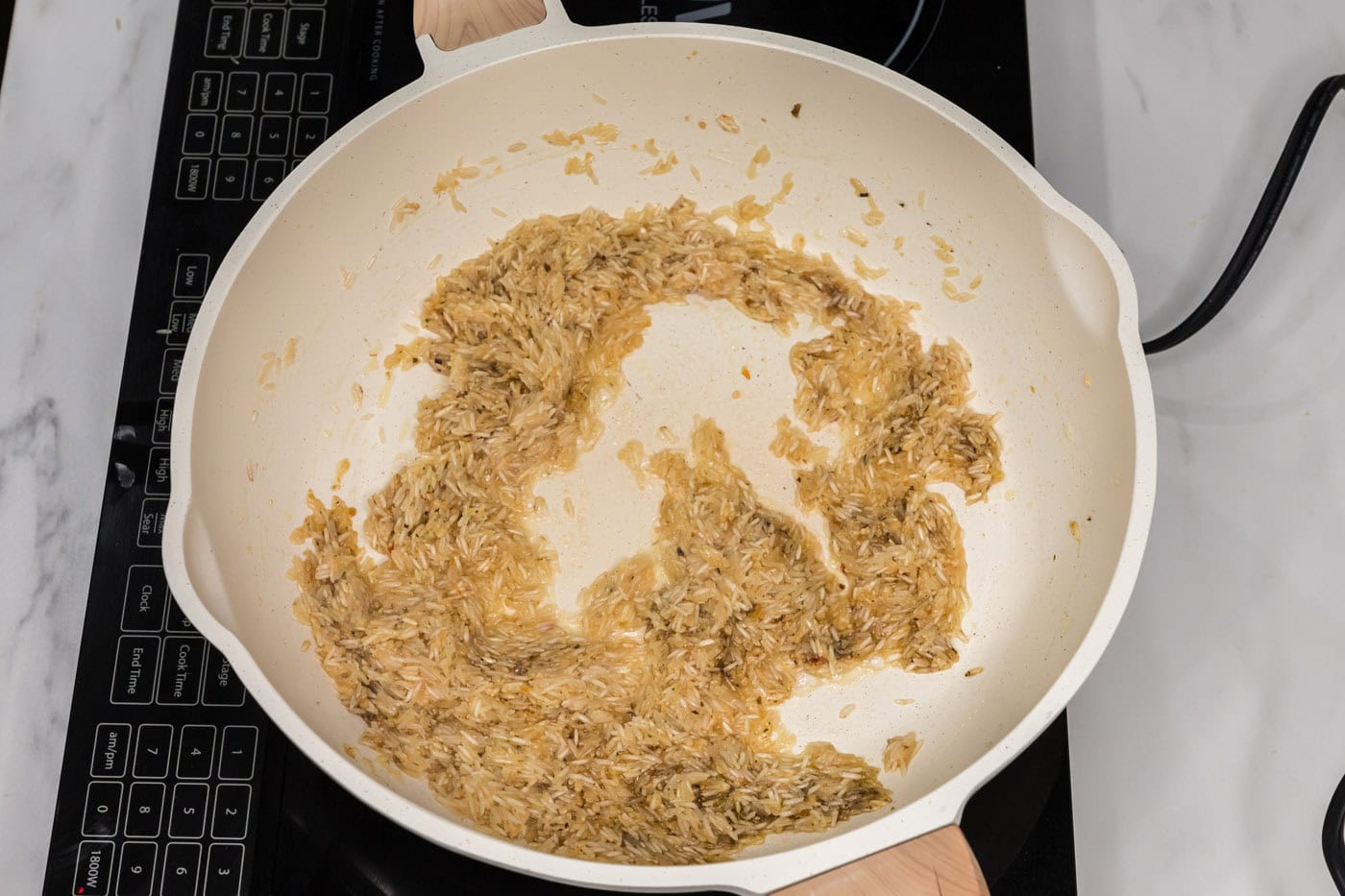 vegetable base added to garlic butter rice in a skillet