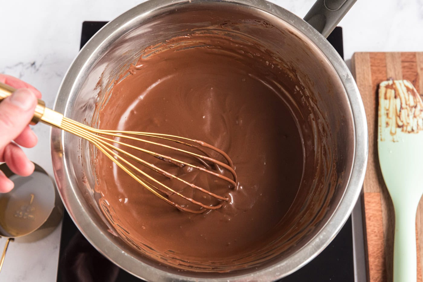 milk and melted chocolate mixture in a bowl with a whisk