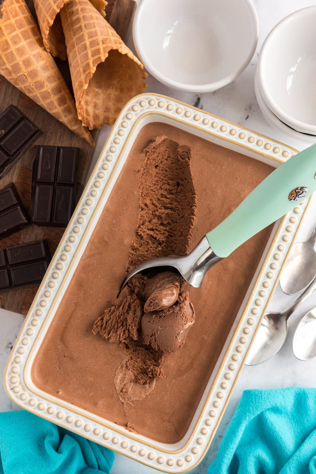 Container of Homemade Chocolate Ice Cream with an ice cream scooper in it