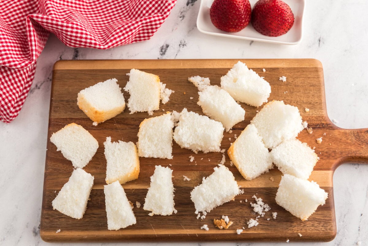cubed angel food cake on a cutting board