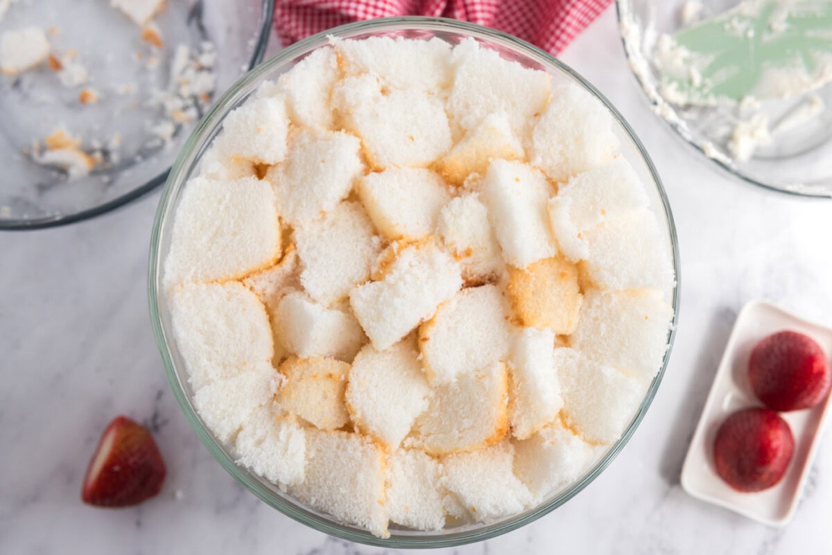 angel food cake cubes on top of strawberry shortcake trifle