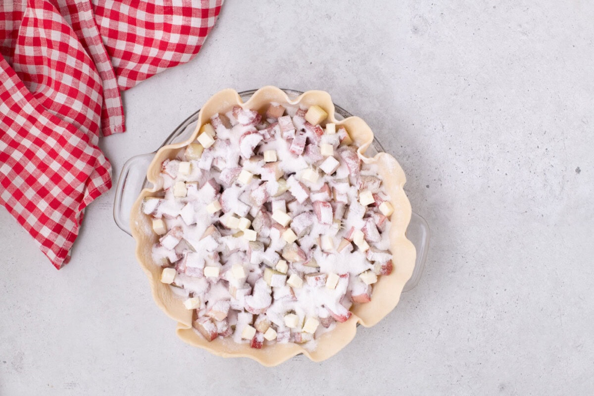 chopped rhubarb sprinkled with sugar in a pie crust