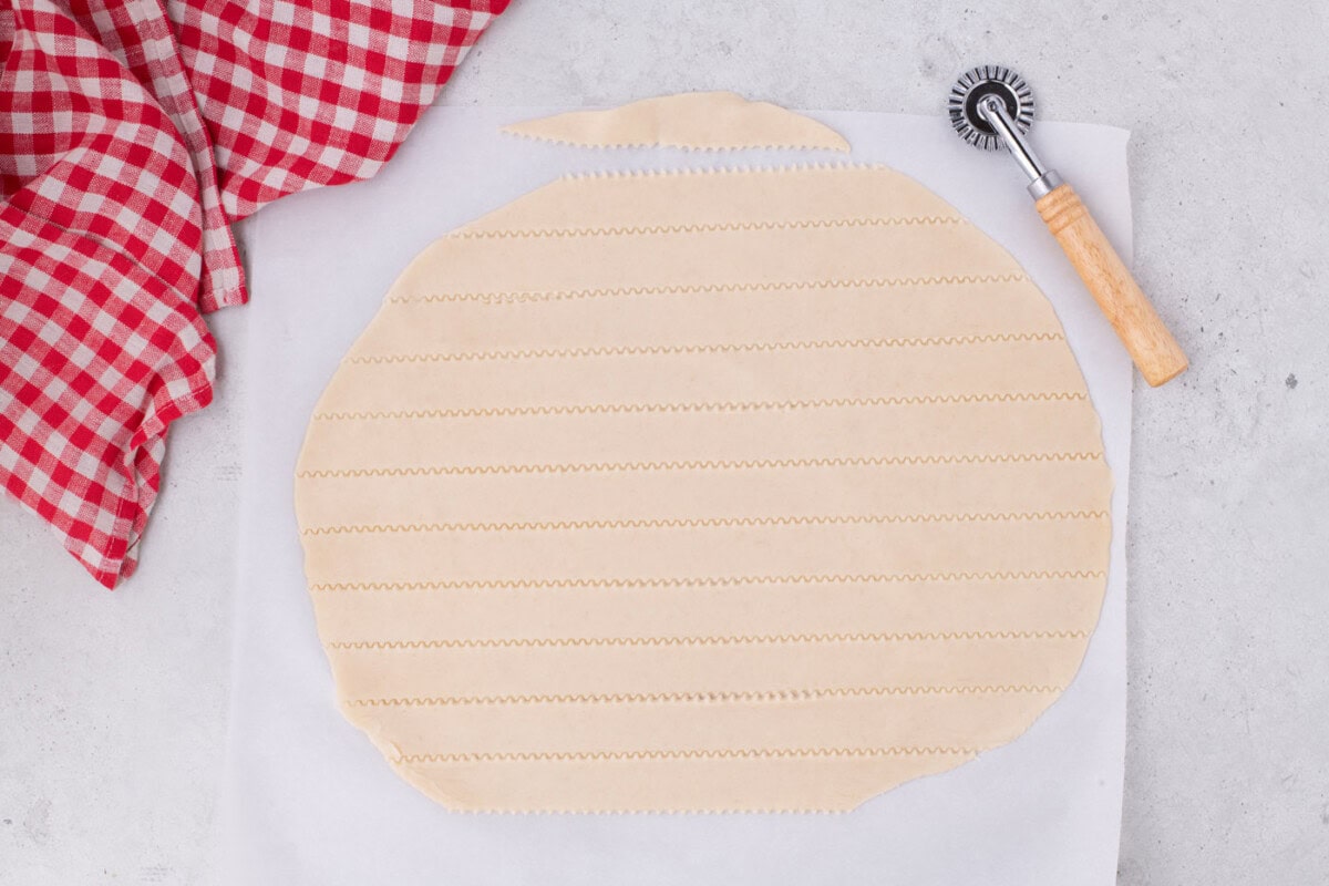 cutting strips of pie crust to make a lattice top