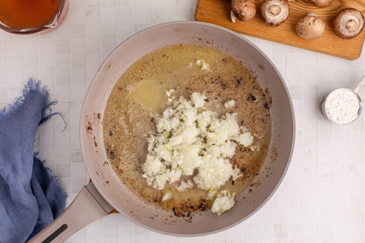 cooking chopped onion in a skillet of butter