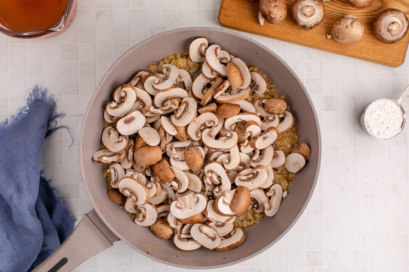 sliced mushrooms added to skillet with sauteed onion