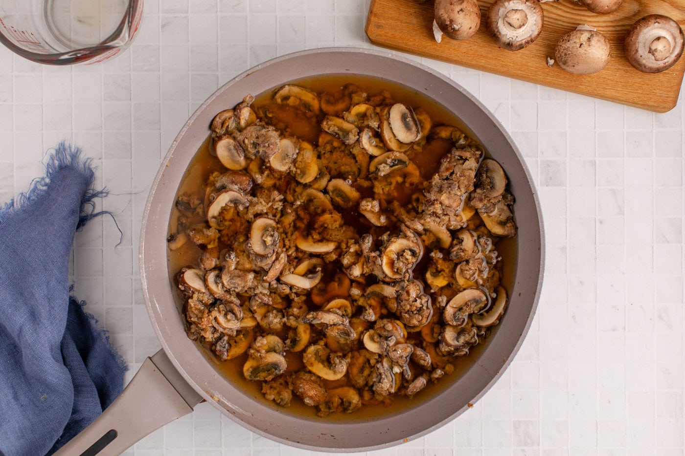 beef broth and Worcestershire sauce added to mushroom sauce in skillet