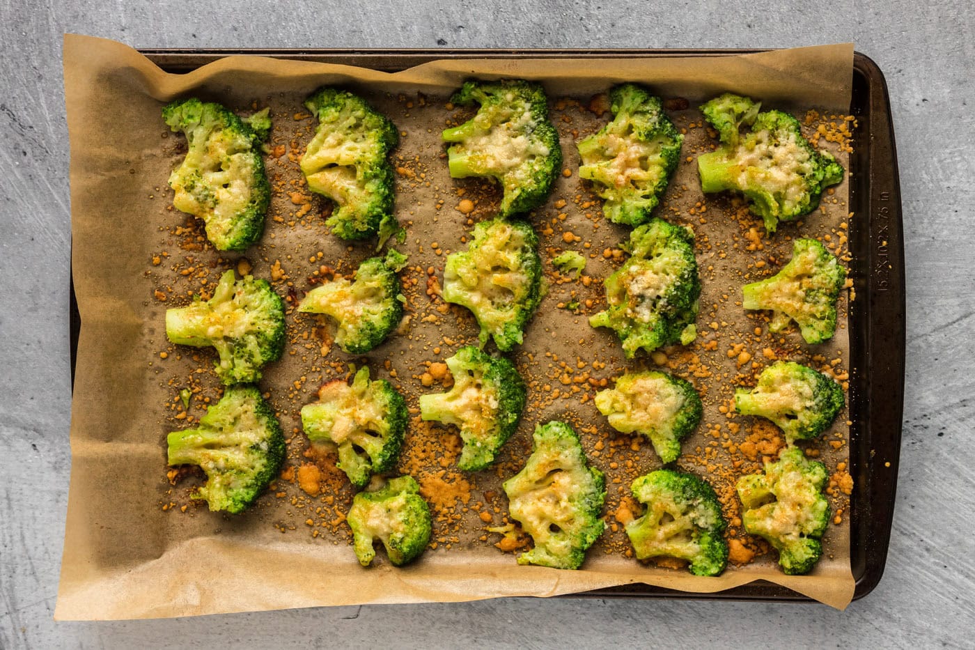 baked smashed broccoli florets on a baking sheet