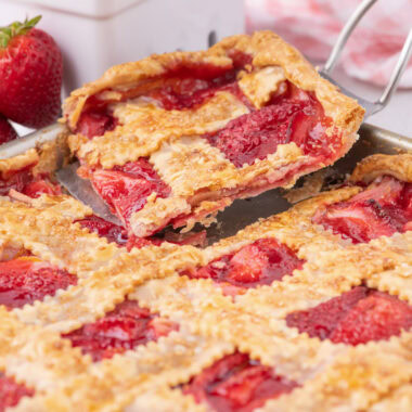Slice of Strawberry Slab Pie being removed from the pan