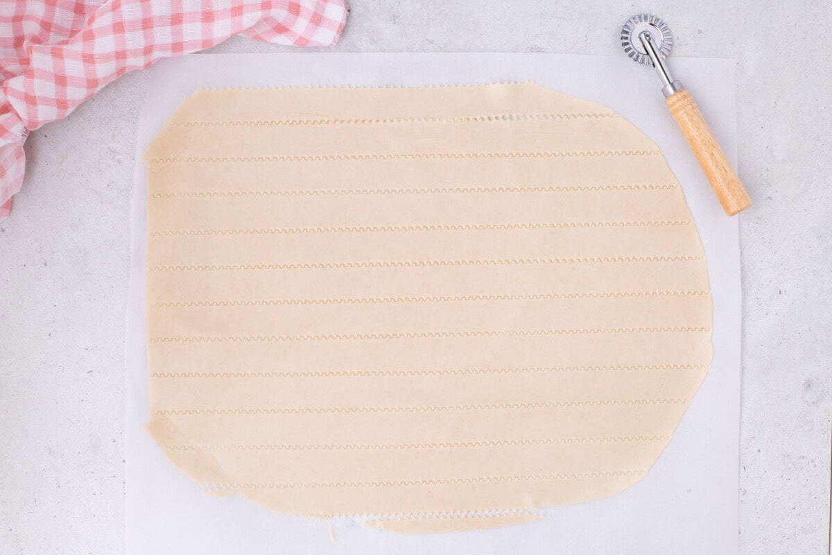 slicing pie crust into strips with a pizza cutter