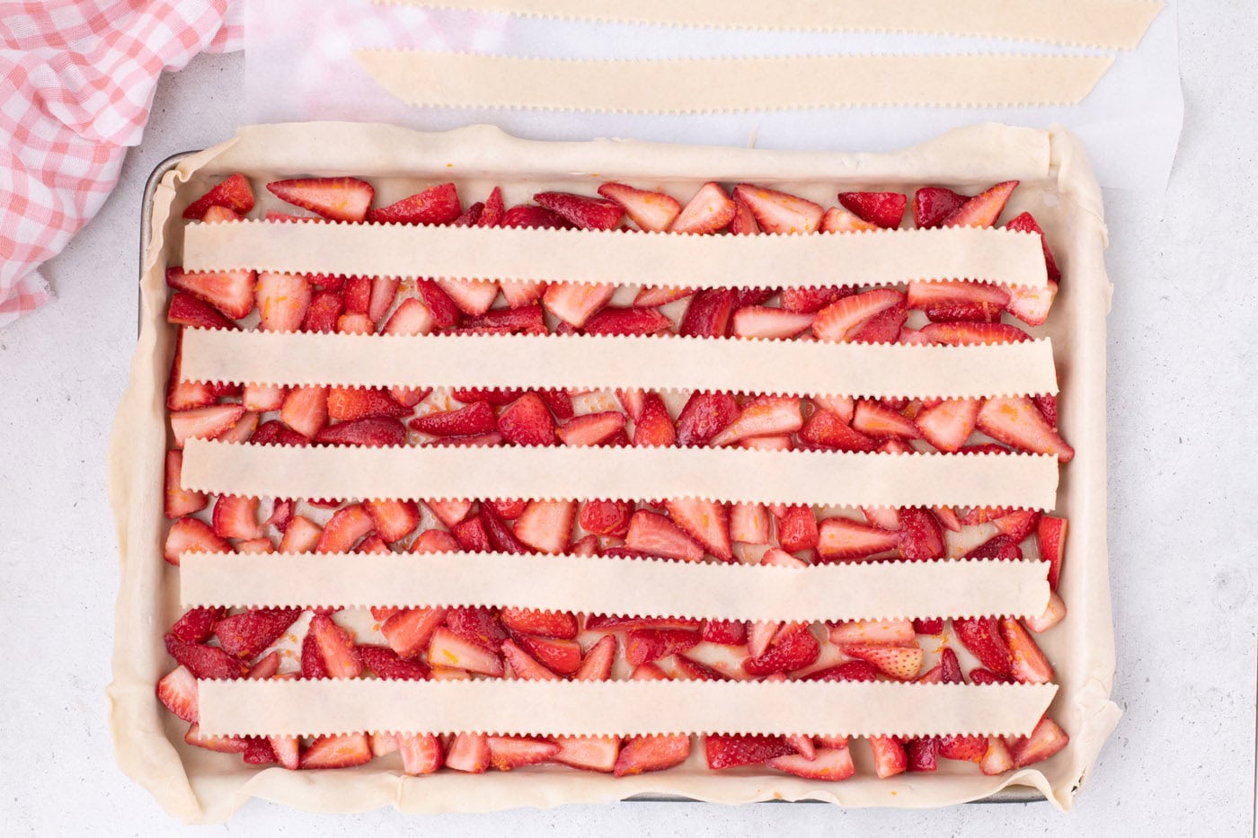 strips of pie crust over strawberries