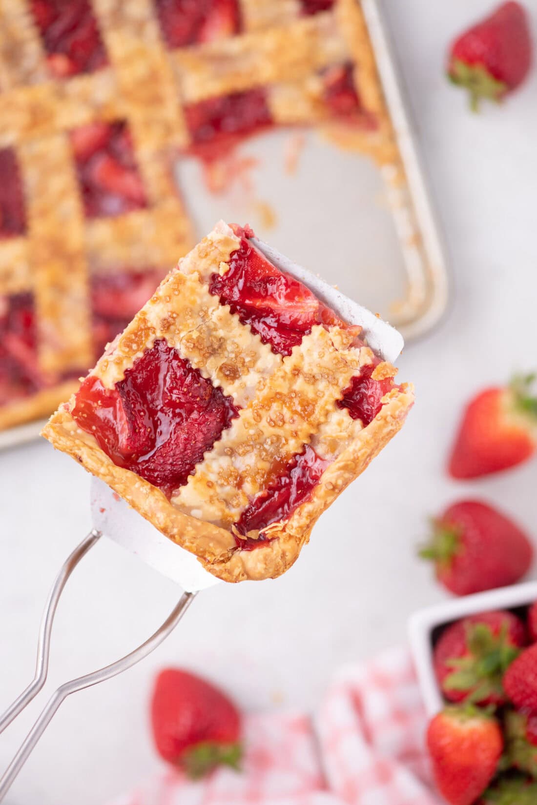 Spatula holding up a slice of Strawberry Slab Pie