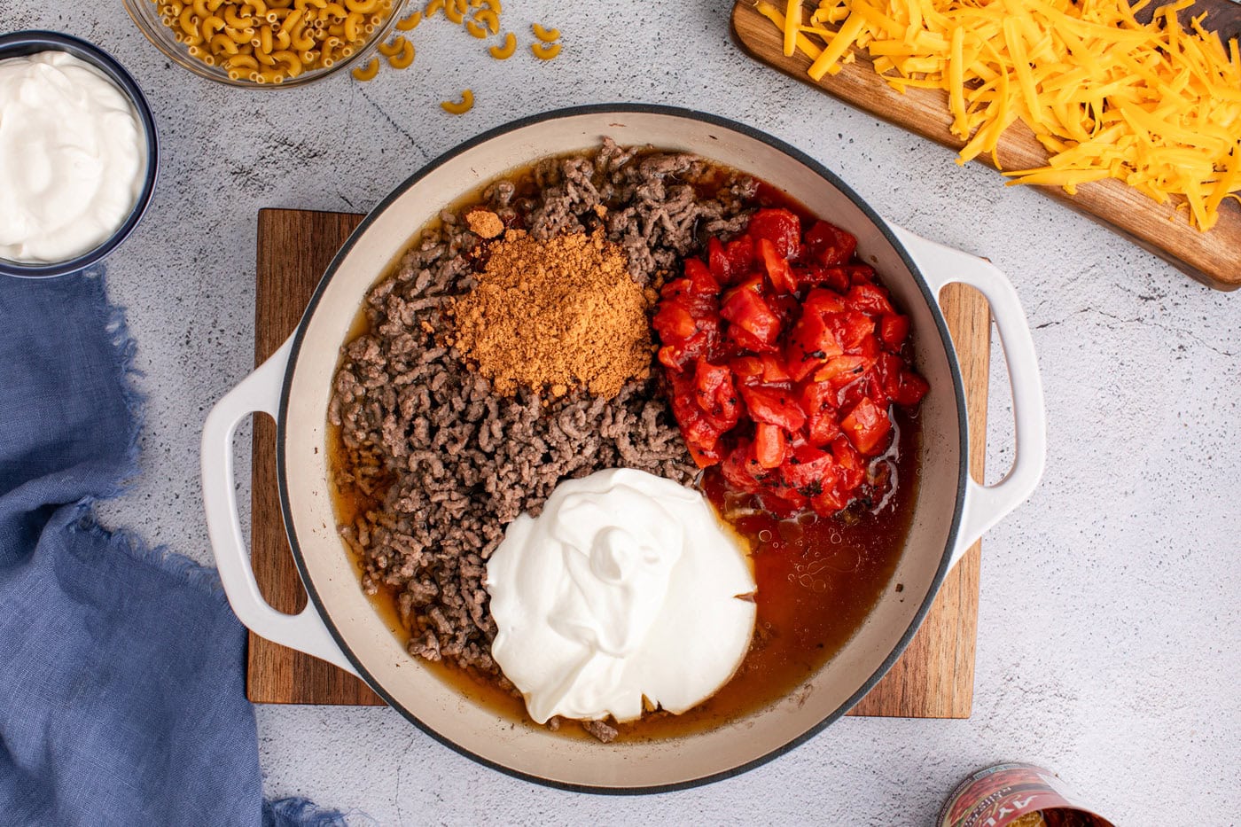 diced tomatoes, taco seasoning, and sour cream added to skillet with ground beef