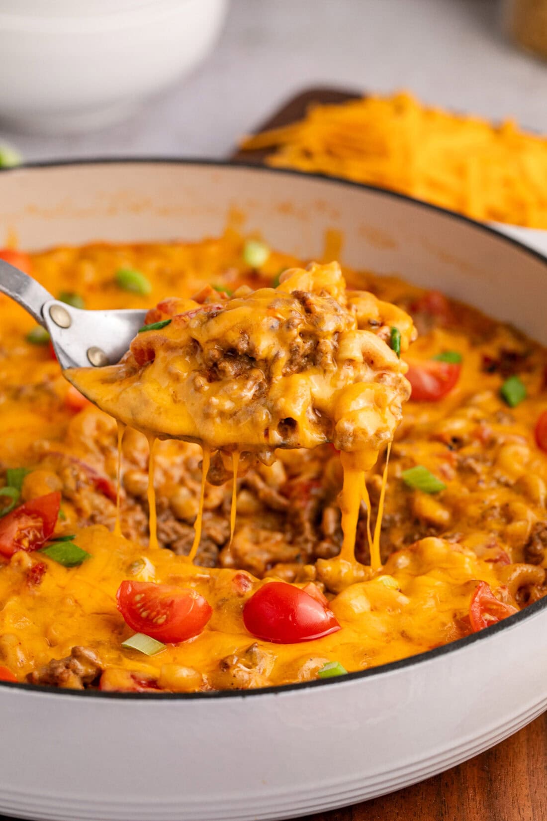 Spoon lifting Taco Macaroni and Cheese out of a skillet