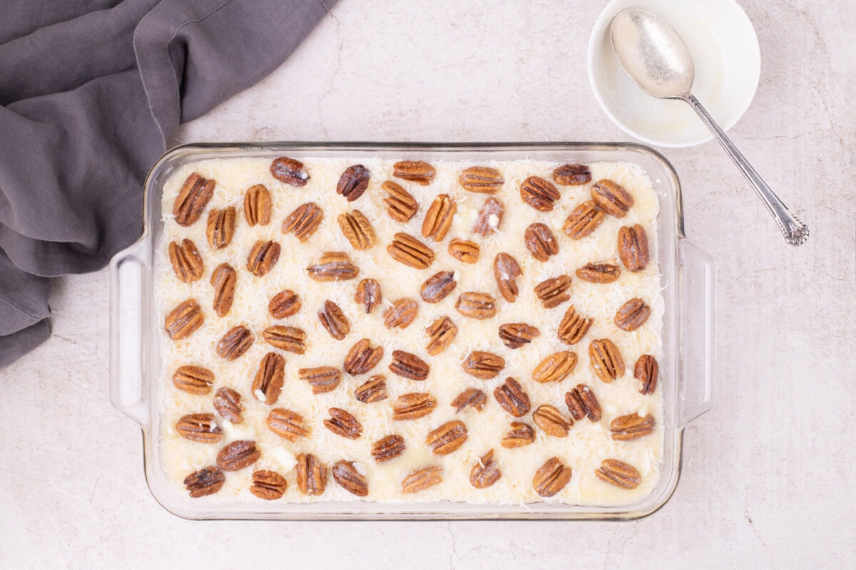 melted butter drizzled over cherry pineapple and pecan dump cake with shredded coconut