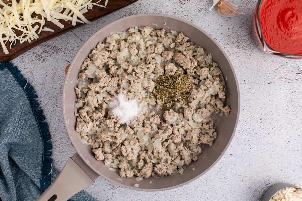 seasonings added to ground turkey mixture in a skillet