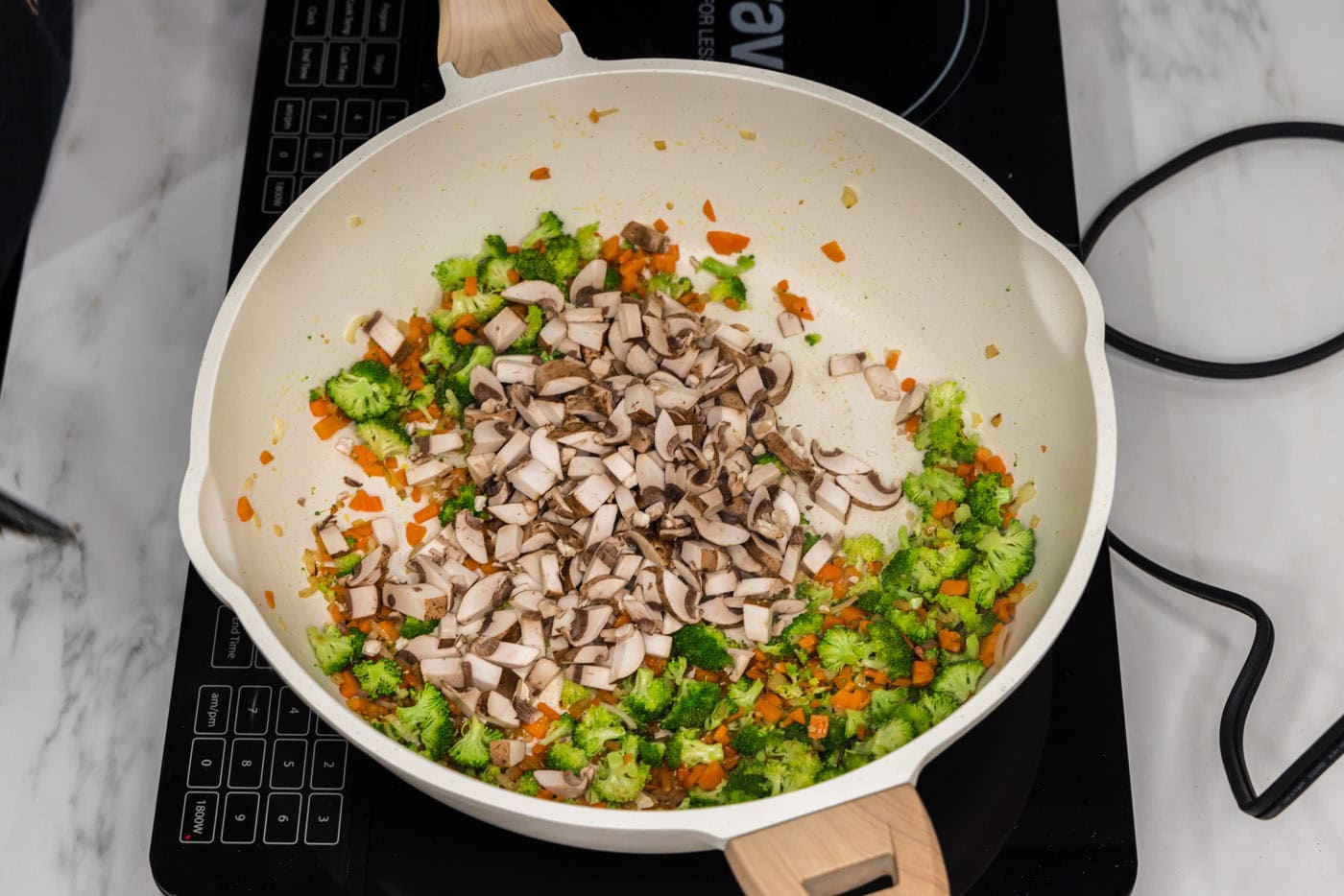 broccoli and mushrooms added to skillet with carrots and garlic