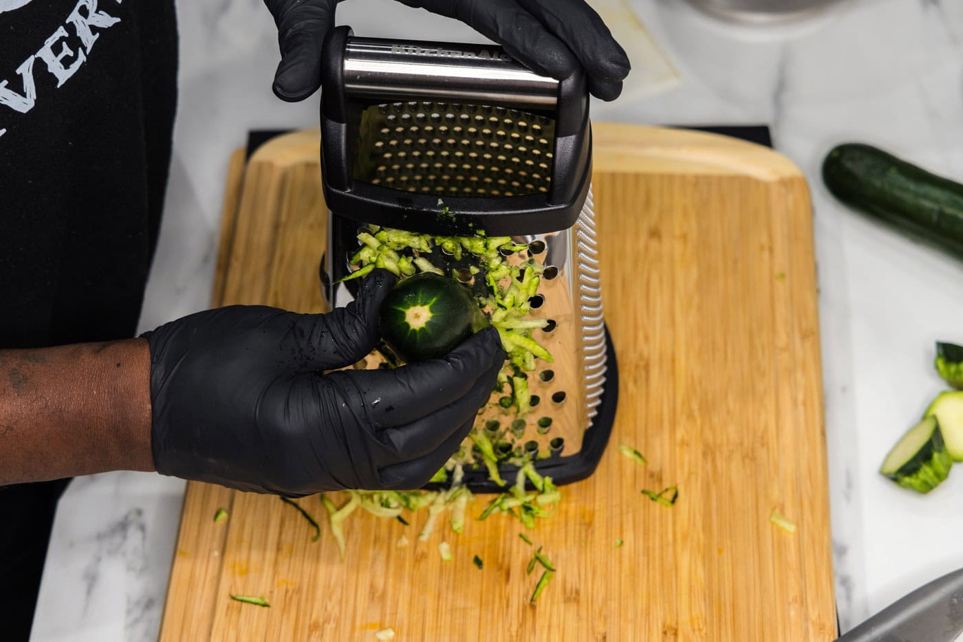 shredding zucchini on a box grater