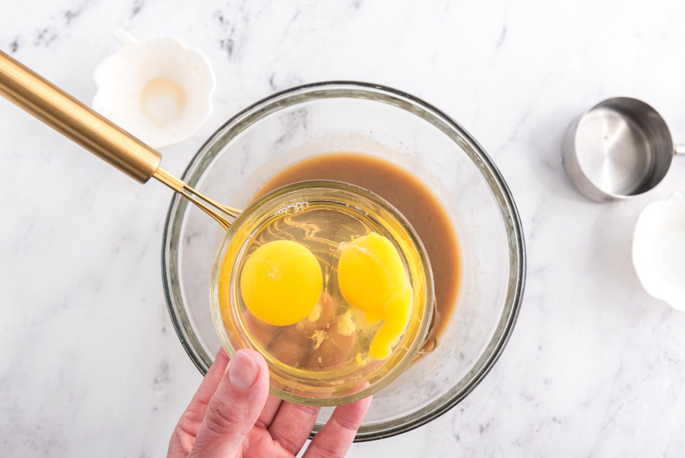 adding eggs to whisked brown sugar, milk, and rum mixture
