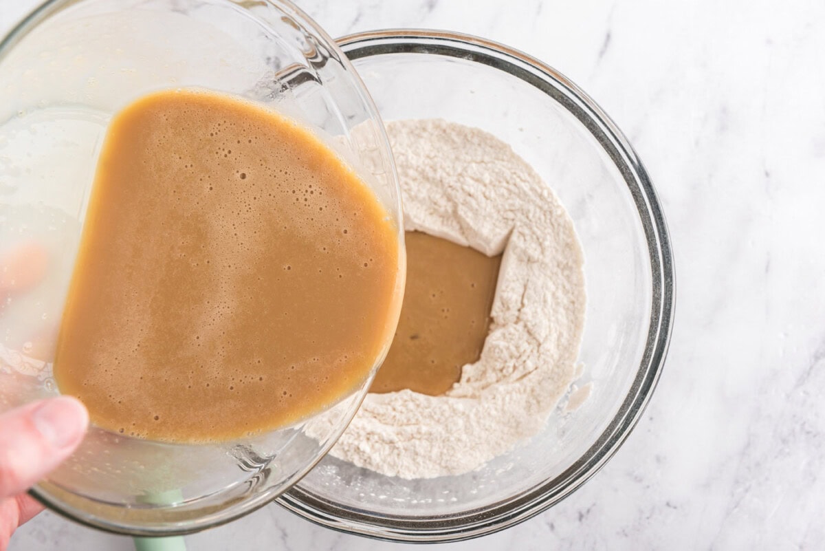 pouring wet ingredients into dry ingredients for muffins
