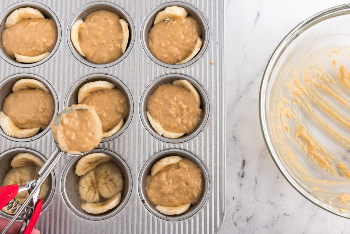 adding muffin ingredients to banana lined muffin pan