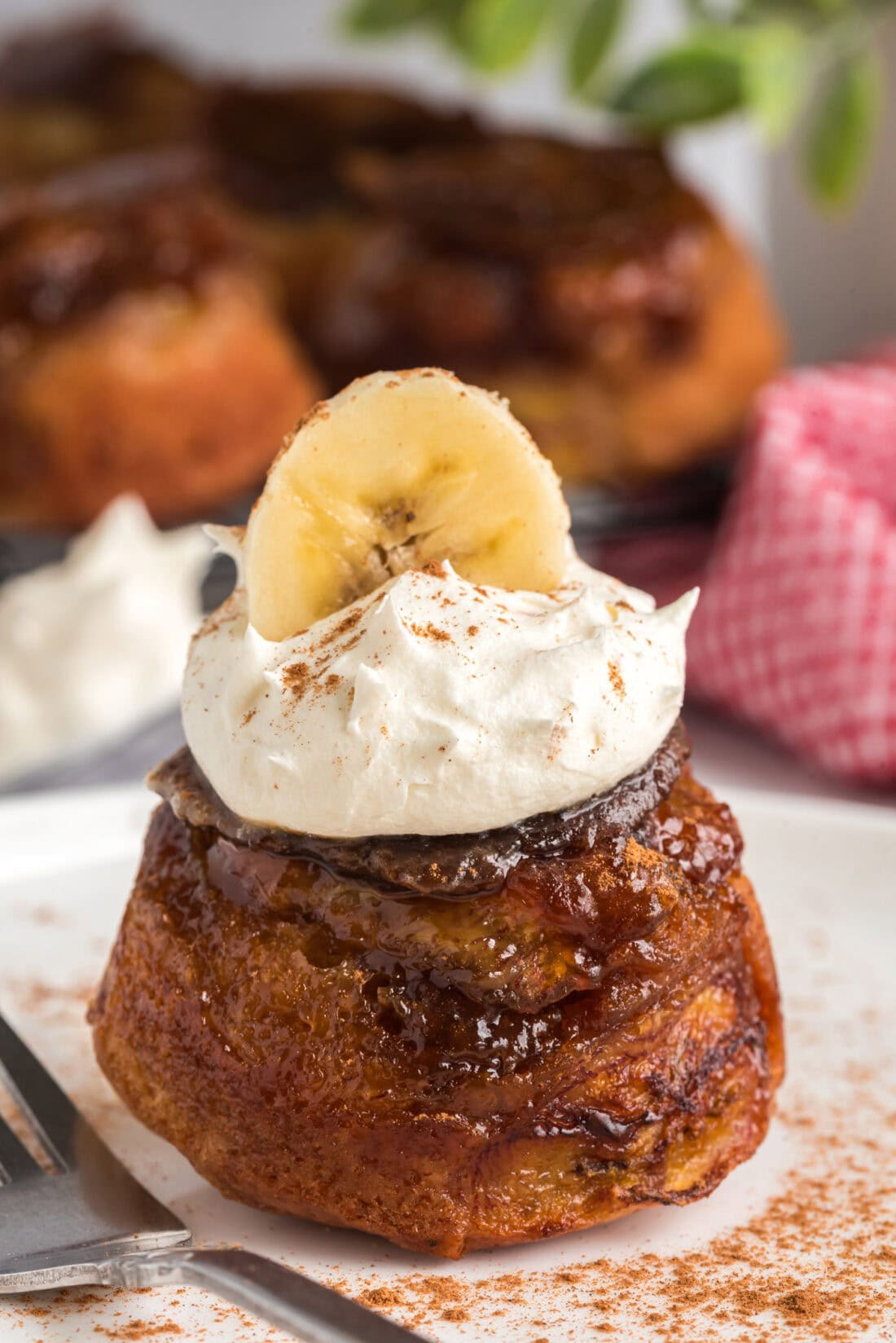 Banana Upside Down Muffin topped with whipped cream and a banana slice