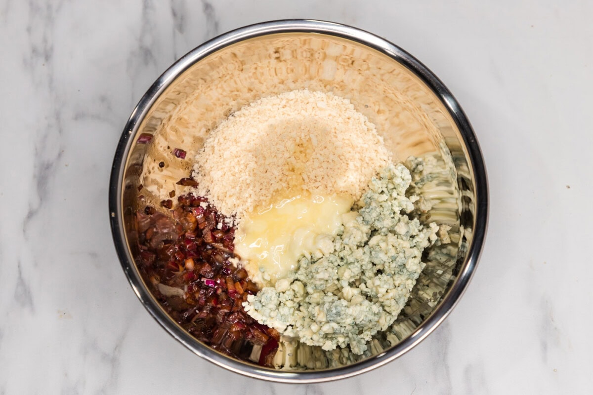 panko, blue cheese crumbles, and red onionmixture in a mixing bowl with butter