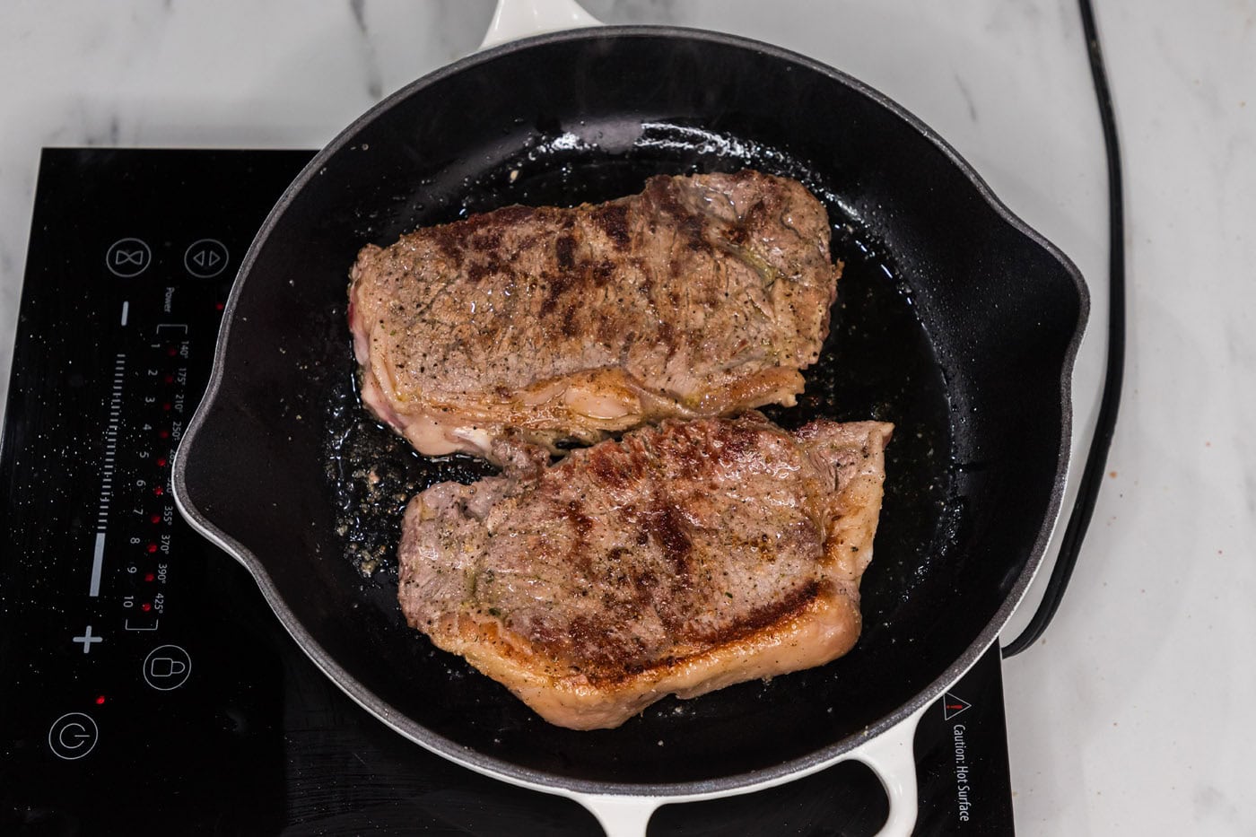 browned new york strip steak in a skillet