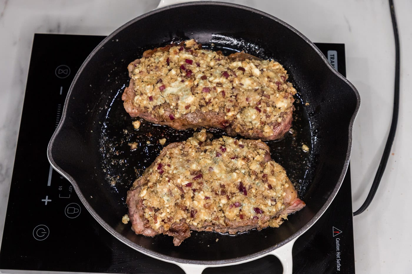 blue cheese crusted steak in a skillet