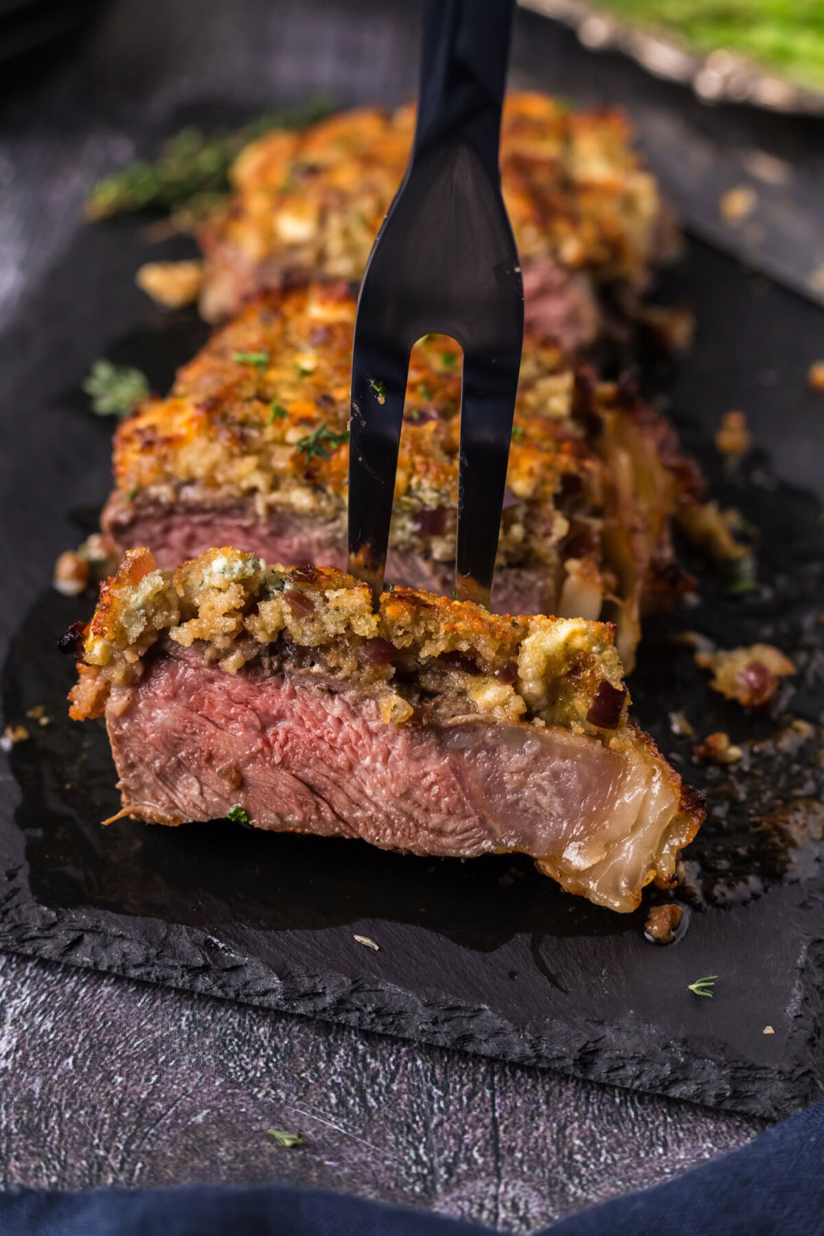 Meat fork in a piece of Blue Cheese Crusted Steak