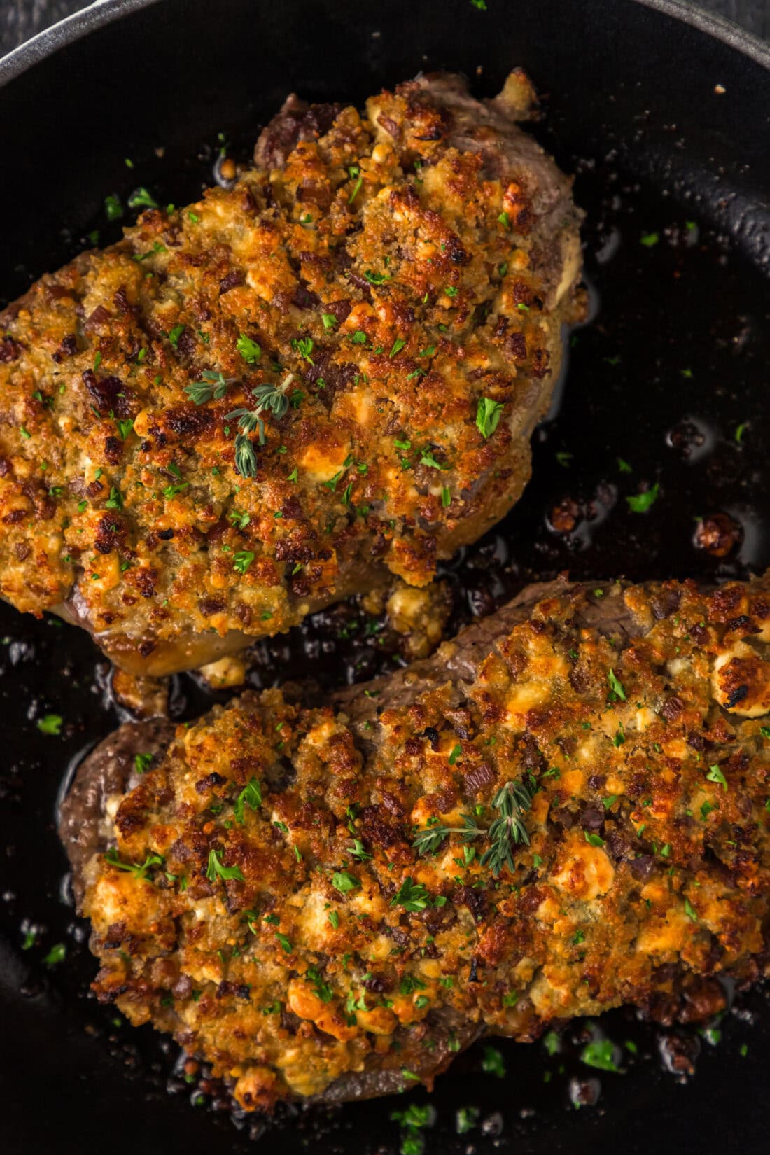 Close up photo of two Blue Cheese Crusted Steaks in a skillet