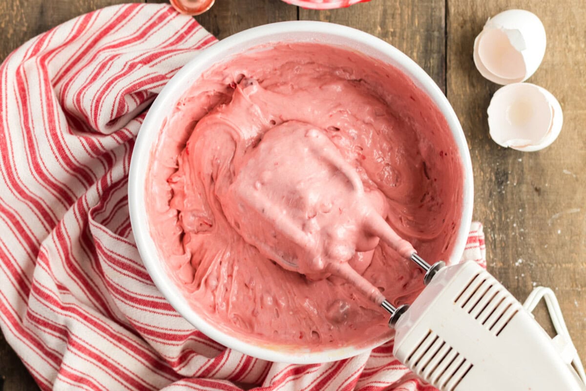 cherry cake mix batter in a bowl with mixer beaters