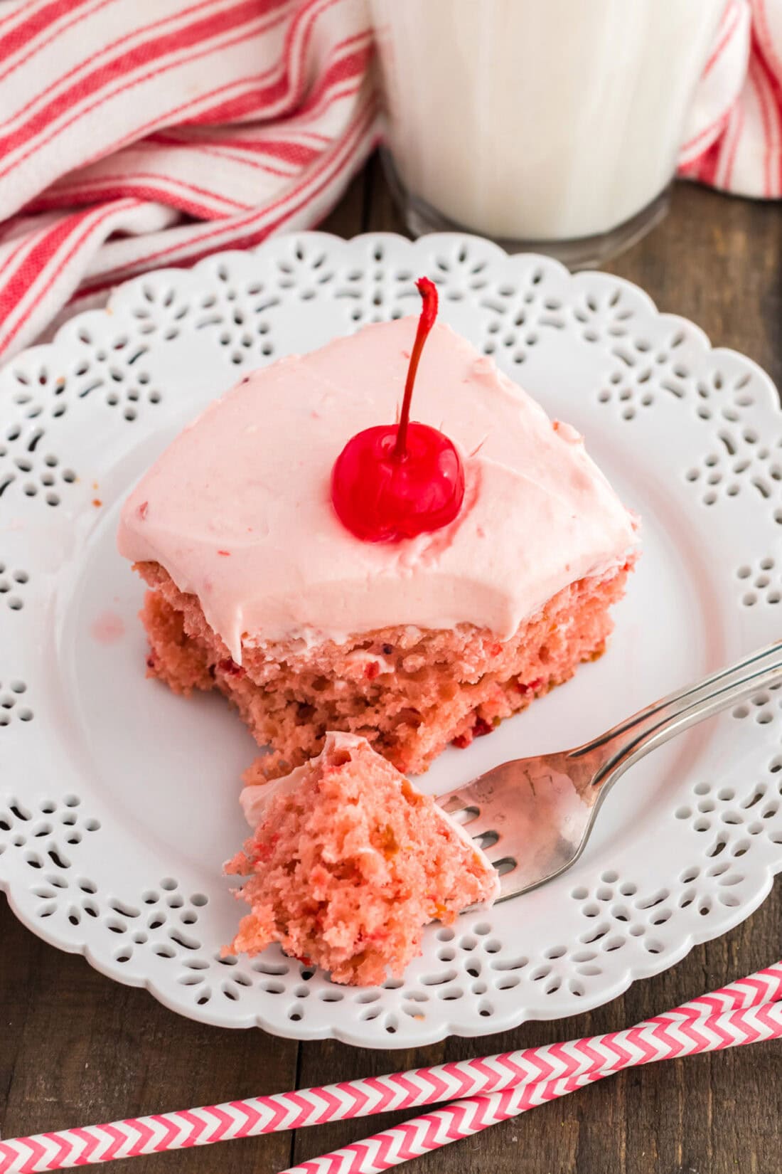 slice of cherry cake on a plate with a bite removed onto a fork