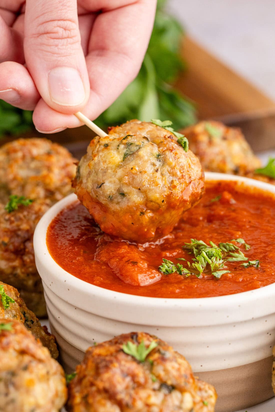Chicken Meatball being dipped in marinara sauce