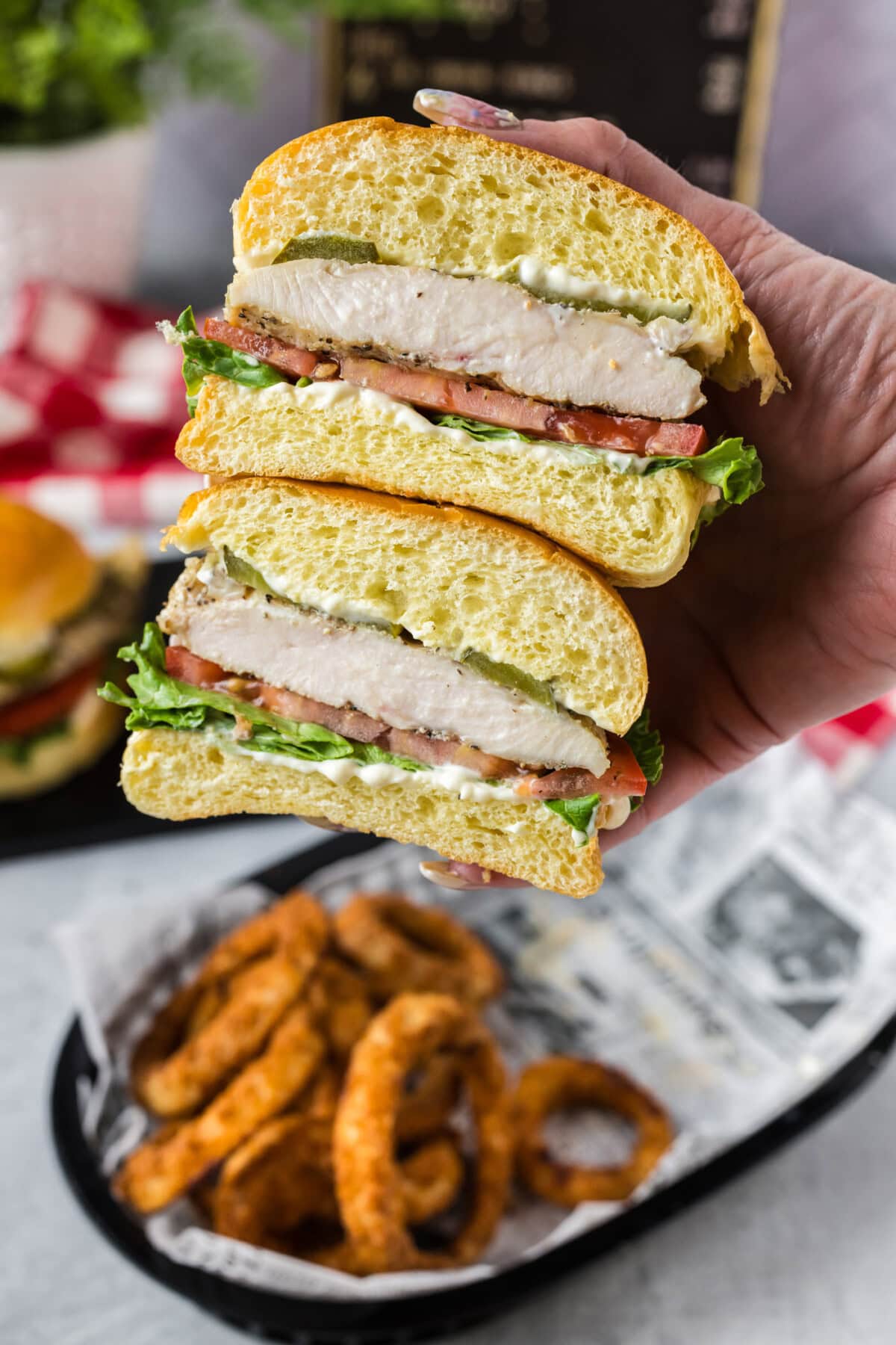 Hand holding a Chicken Sandwich that has been cut in half