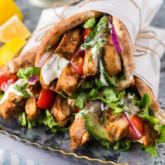 Close up photo of Chicken Shawarma pita wraps stacked on top of each other