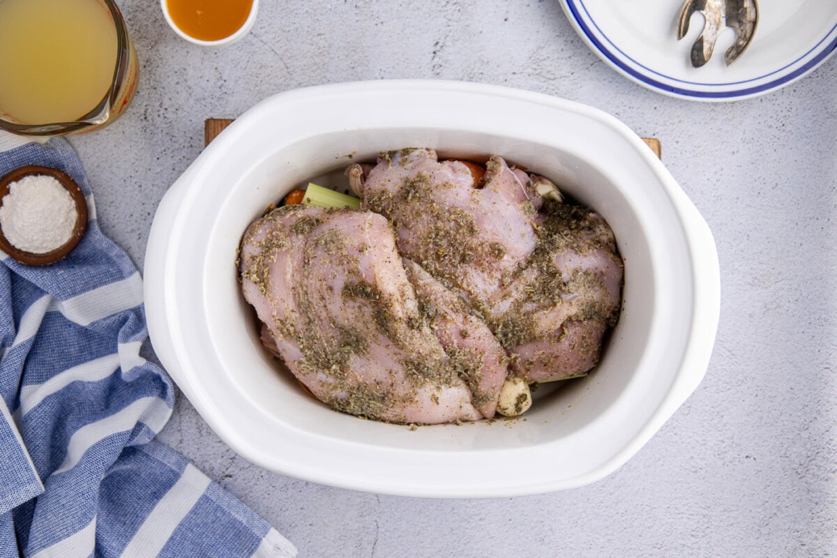 seasoned turkey breasts in a slow cooker crock