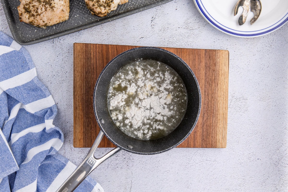 adding flour to chicken stock and apple cider mixture