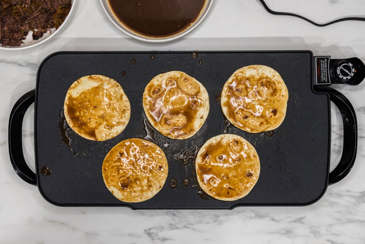 tortillas soaked in au just on a griddle